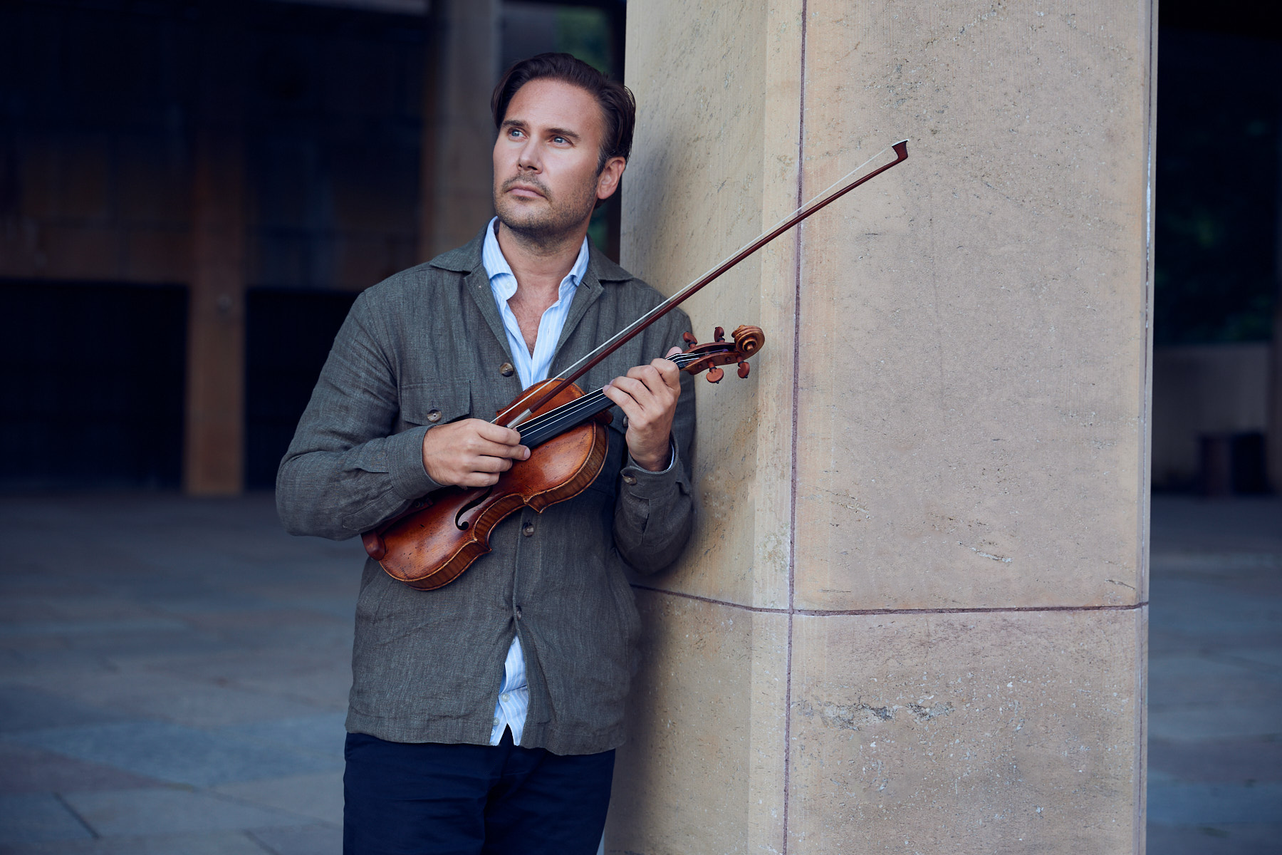 Christian Svarfvar holding his violin, photographed by Fredrick Francke